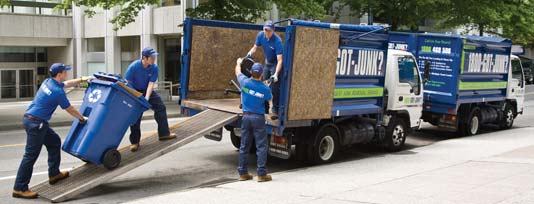 Truck team members loading junk onto a 1800-GOT-JUNK? truck
